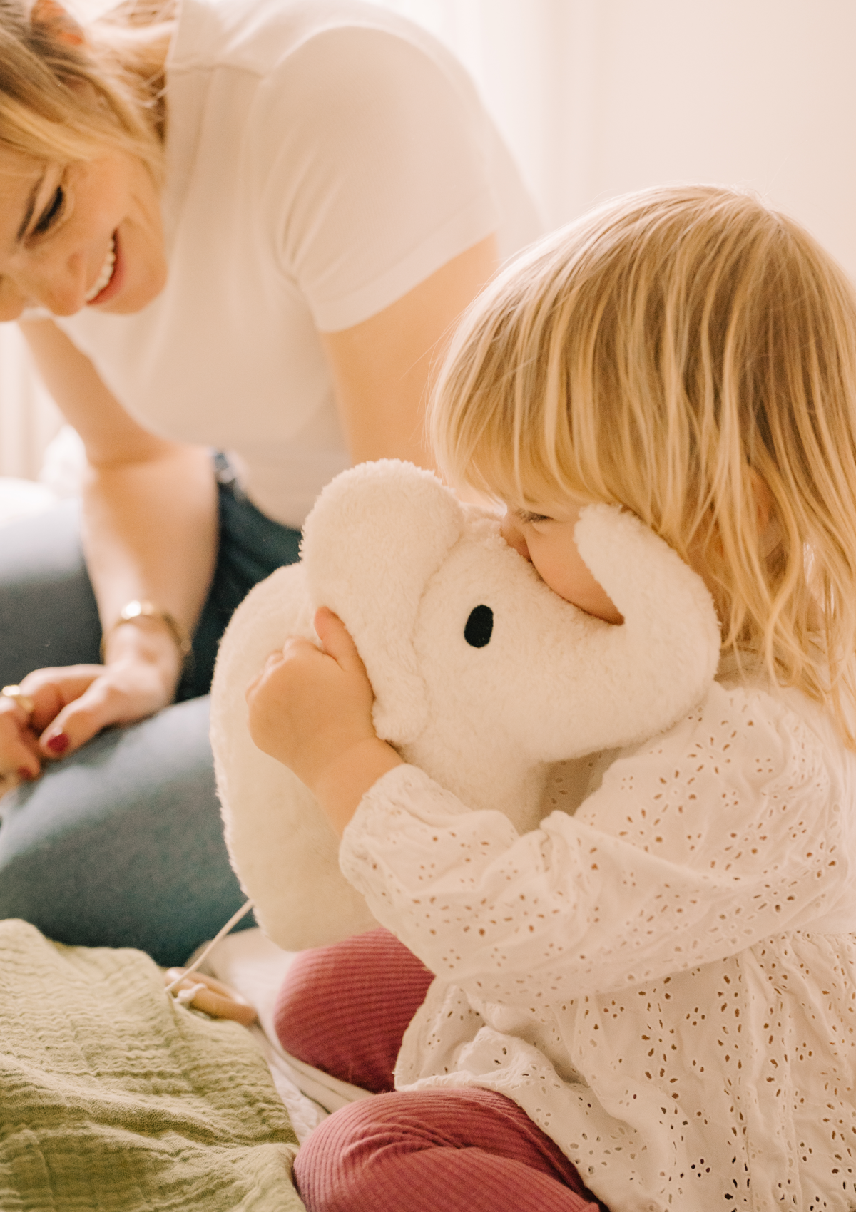 Kleinkind kuschelt mit Plüschelefant