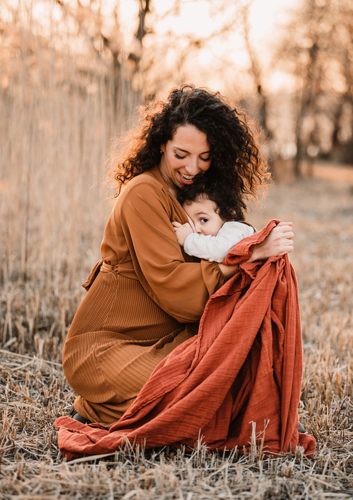Mutter und Kind in Herbstlandschaft mit Petit Stellou NOOSHI Tuch rostrot brick