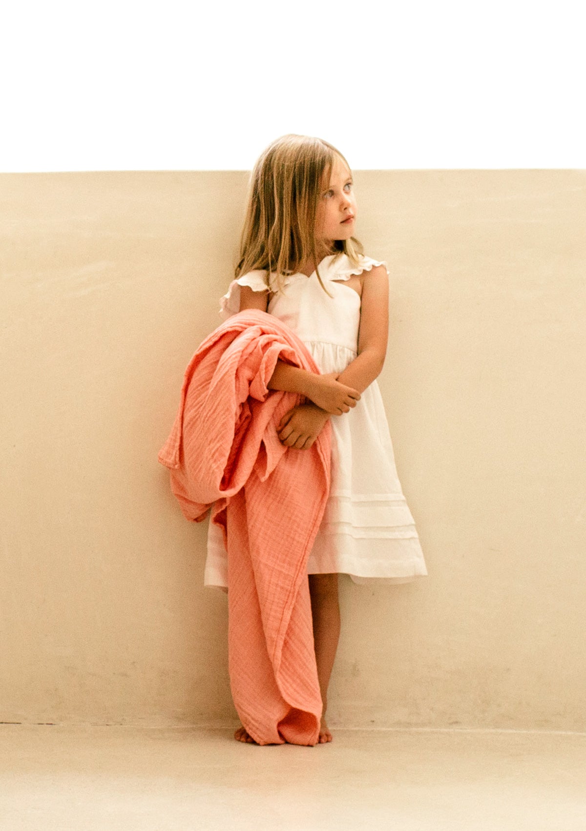 Mädchen mit Petit Stellou NOOSHI Decke Peach Farbe orange-rosa in der Hand